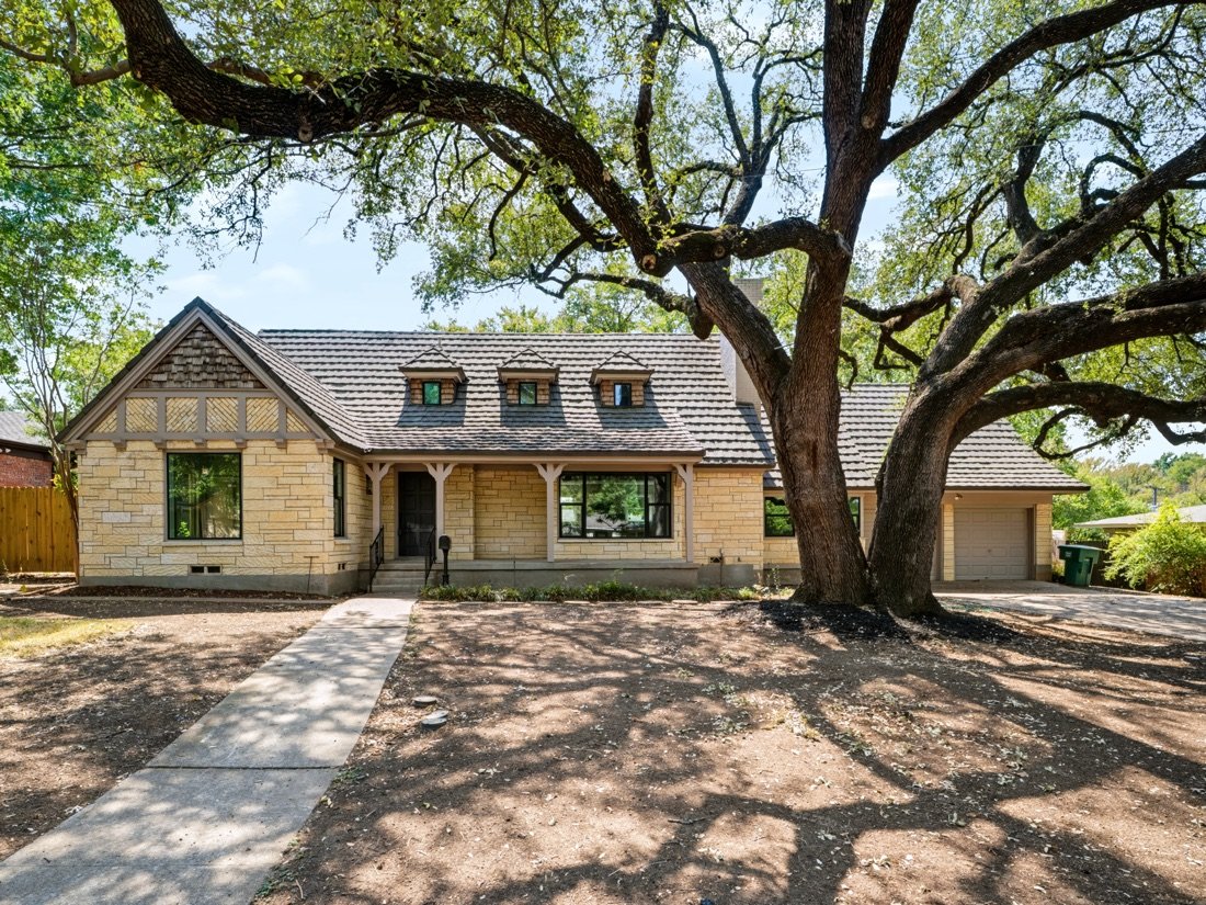 The same house seen from the street under live oaks, Fort Worth